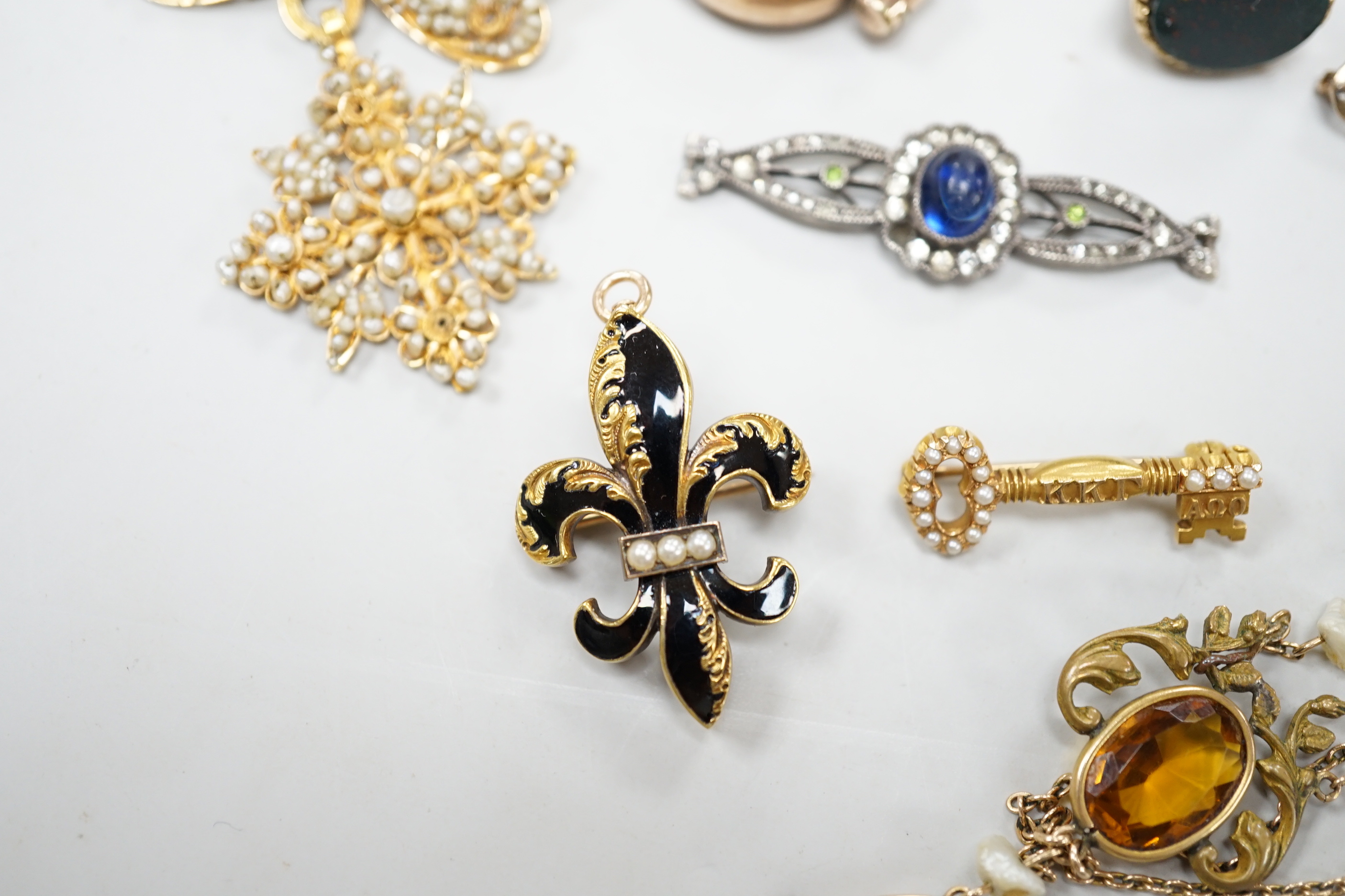 A small group of antique and later jewellery, including 9ct gold and bloodstone fob seal, a 1930's yellow metal and seed pearl set key brooch, 14k and black enamel brooch, spinning fob pendant, coral hand charm, 10k and